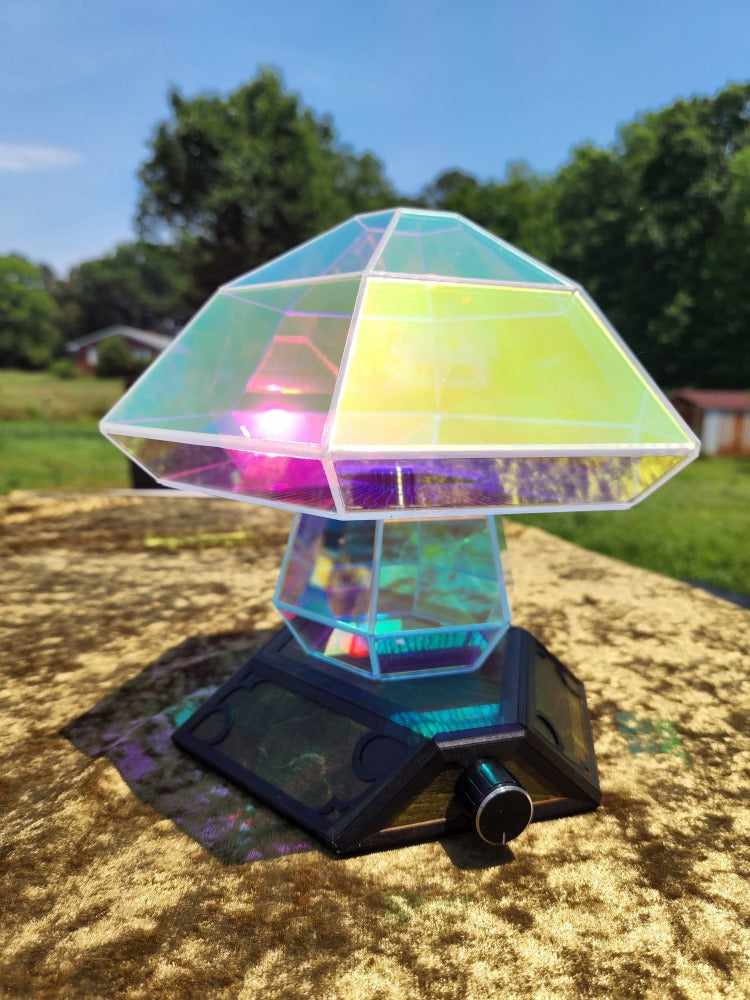 Acrylic Boletus Lumos prism lamp, outside on a green blanket on a sunny day.